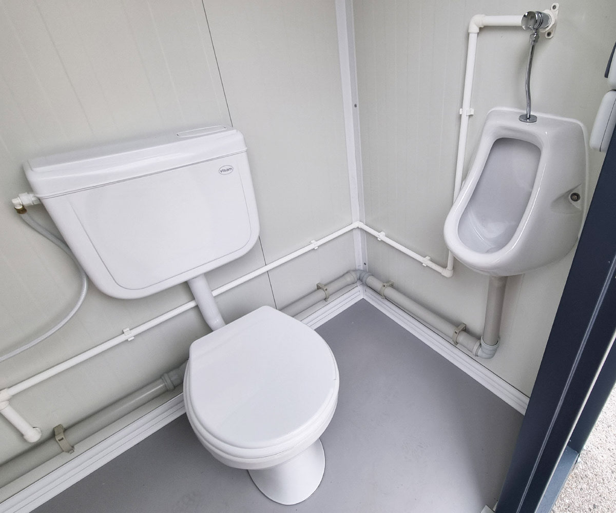 Contenedor sanitario nuevo de formato compacto, equipado con WC, urinario y lavabo.